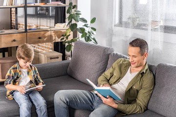 Obraz premium father with book and son with tablet