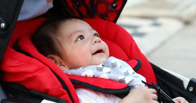 cute boy child laughing happy smile in baby stroller carriage seat