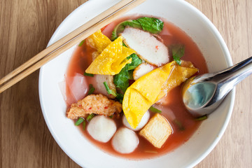 red noodle soup with fish meat ball, fofu Yen ta fo, Best noodle menu in Thailand. Asian food Noodle on the wood table in the white bowl with spoon and chopstick 