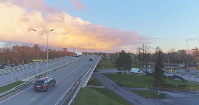 Aerial footage of traffic, cars and buses on the bridge, Jõhvi, Estonia. Beautiful sunset with amazing pink clouds over the city.