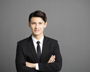 Happy smiling businessman with gray background.