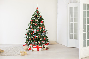 Christmas tree with red gifts in the white room Christmas