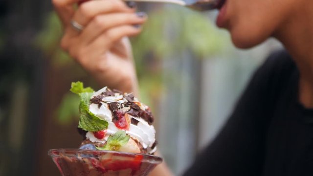 Young Mixed Race Girl Enjoying Eating Healthy Chocolate Vanilla Strawberry Mint Ice-Cream in Cafe. Close Up Female Hand Taking Dessert with Spoon. 4K, Slowmotion.
