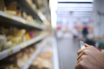Close-up. The girl chooses the products in the shop. Blurred background of the store