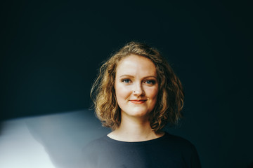 Jungeblonde Frau schaut lächelnd in die Kamera