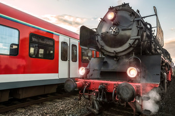 Fototapeta na wymiar old steam train and modern electric train in a race
