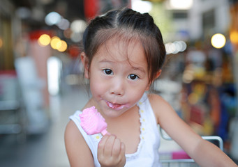 Cute little asian child girl eating ice-cream.