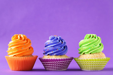 Tasty cupcakes on a purple background