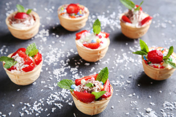 Dessert tartlets with strawberries on grey wooden table