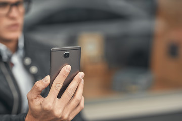 Close-up. A cute guy does selfie on a smartphone. On the street
