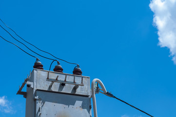 Metal high voltage transformer on sky and cloud background