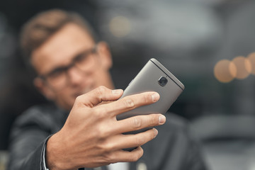 Close-up. A cute guy does selfie on a smartphone. On the street
