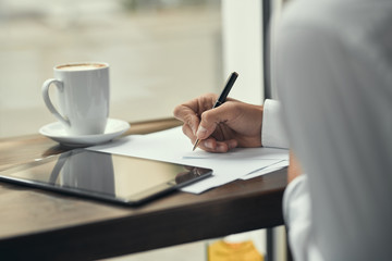 Close-up. Young man. Pen in hand. The tablet. Documentation. Job. Office. A cafe