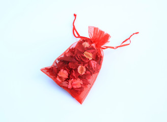 Dry flowers petals in a red cloth isolated on white background.