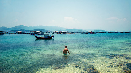 the guy in the blue ocean against the background of the ships