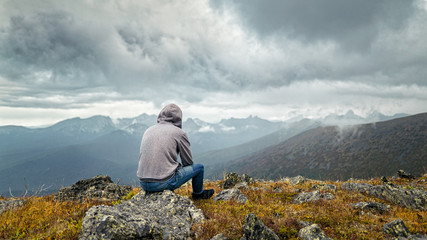 Man sitting on a mountain and thinks