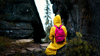 the girl in yellow sitting on a stump