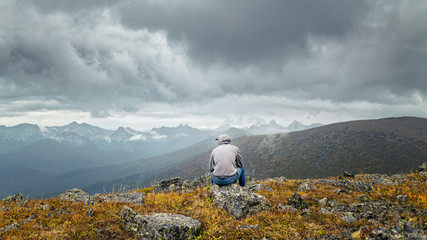 Man sitting on a mountain and thinks