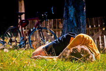 Obraz premium Rider resting on the grass near his street bicycle 