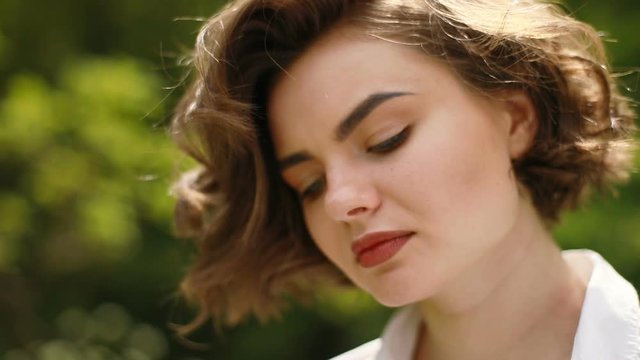 Wid look. Close up portrait of young attractive woman looking to camera. Close-up shot of a woman opening her blue eyes outdoor