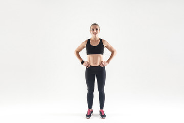 Obraz premium Beautiful woman in sports wear, looking at camera and smiling