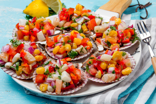 Peruvian style food Scallops a la chalaca. Scallops with onion, tomato, maize, cilantro and lemon
