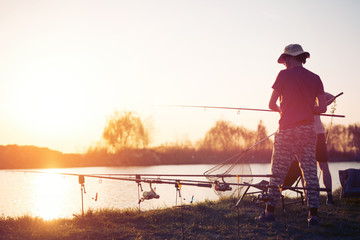 Fototapeta na wymiar Fishing as recreation and sports displayed by fisherman at lake