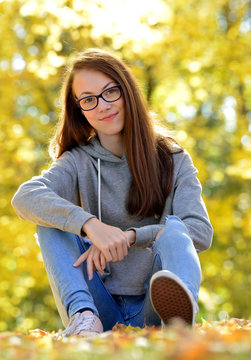 Girl with glasses in autumn park.