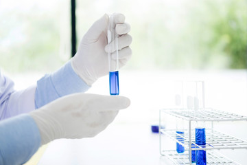 Fototapeta premium Asian scientific researcher working in laboratory holds test tube in hand a liquid solution analysis using chemical manufacturing.