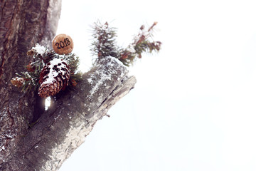 festive winter holidays/ wine cork with the number 2018 lies on a pine branch decorating a tree