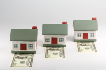 Three houses stand on the bills for a hundred dollars