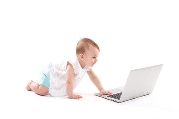 curious smiling child sitting near the laptop on a white background
