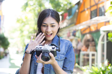 Portrait of Happy Traveler Woman in city. Asian women Hold Retro Camera for Take Photo, People with Happy emotions.
