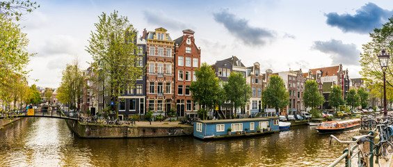 Naklejka premium Panorama d'un canal et ses maisons typiques à Amsterdam, Hollande, Pays-bas