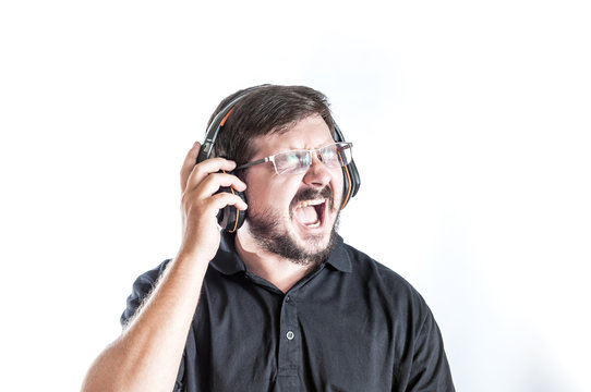 Portrait of 30 years old caucasian man singing loud song and listen music by headphones