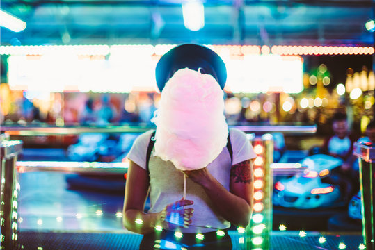 Stylish woman covering face with sugar cloud
