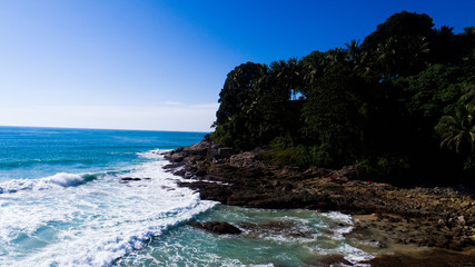 Fototapeta premium Aerial drone view of beautiful tropical island beach and waves crashing coastline cliff during sunny summer day