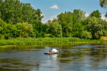 Tourists float on a raft down the river - a summer holiday. Tourists on the Seversky Donets River, Ukraine - summer landscape.