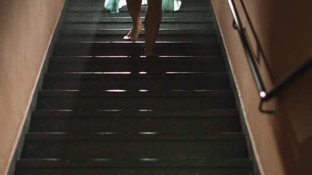 Pernas de mulher descem a escada