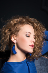 Fototapeta premium Profile of a beautiful girl with voluminous curly hair on a black background