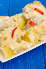 cod fish with potato and sauce on white dish