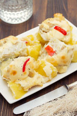 cod fish with potato and sauce on white dish