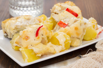 cod fish with potato and sauce on white dish