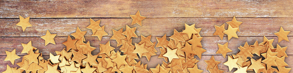 Scattered gold confetti stars on wooden planks - panorama