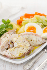 boiled fish with boiled vegetables on white plate