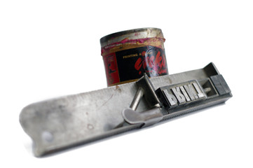 Linotype text in stick spelling print with can of paint on white background