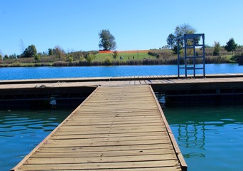 The wood dock at the lake of the park.