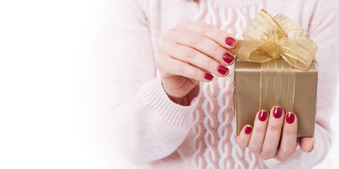 Woman holding Christmas present. Gift box with ribbon.