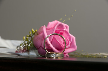 pink rose with wedding rings