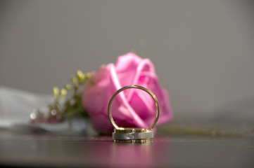 pink rose with wedding rings